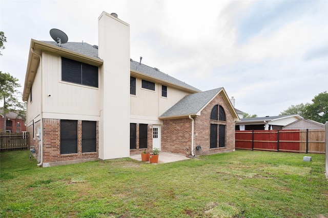 rear view of property featuring brick siding, a chimney, a patio area, and roof with shingles