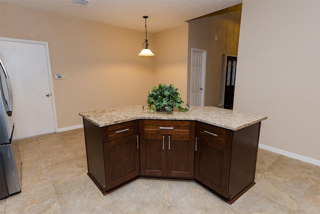 kitchen featuring dark brown cabinets, pendant lighting, baseboards, and light stone counters
