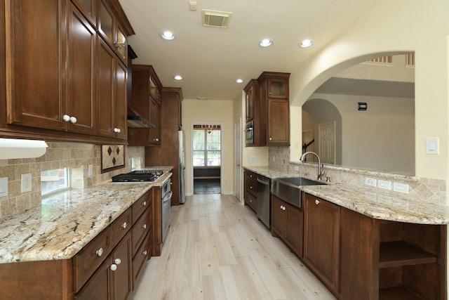 10606 Maidstone Manor Ct, Spring, TX 77379 - kitchen with a sink, appliances with stainless steel finishes, recessed lighting, decorative backsplash, and light stone countertops