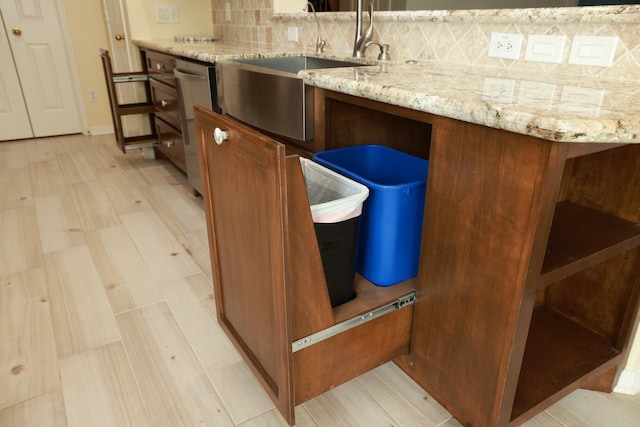10606 Maidstone Manor Ct, Spring, TX 77379 - kitchen view of backsplash, stainless steel dishwasher, light stone countertops, a sink, and brown cabinets