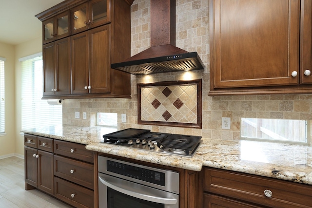 10606 Maidstone Manor Ct, Spring, TX 77379 - kitchen featuring stainless steel appliances, wall chimney exhaust hood, light stone counters, and tasteful backsplash