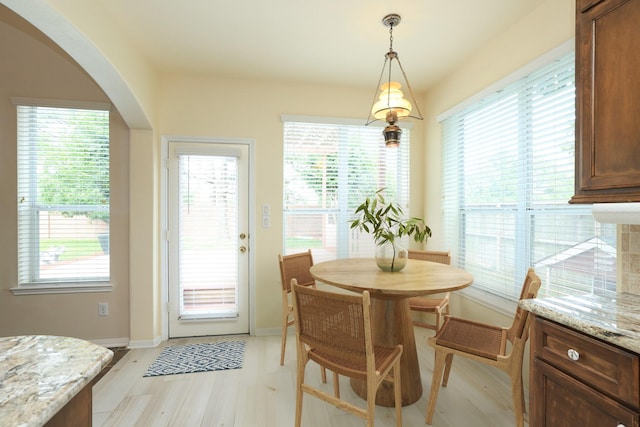 10606 Maidstone Manor Ct, Spring, TX 77379 - dining space with arched walkways, light wood-style flooring, and baseboards