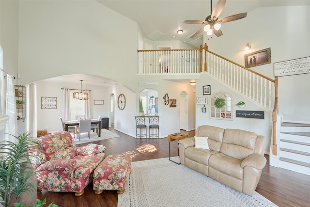 7503 Revelwood Dr, Magnolia, TX 77354 - living area with arched walkways, wood finished floors, high vaulted ceiling, a ceiling fan, and stairway