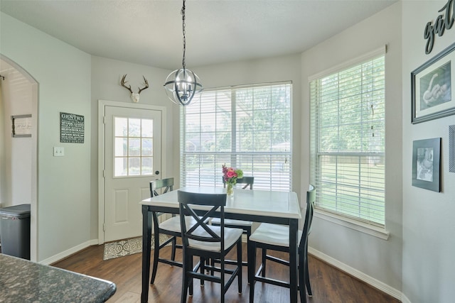7503 Revelwood Dr, Magnolia, TX 77354 - dining area featuring arched walkways, baseboards, and dark wood-style flooring