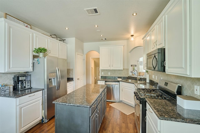 7503 Revelwood Dr, Magnolia, TX 77354 - kitchen featuring appliances with stainless steel finishes, arched walkways, a sink, tasteful backsplash, and recessed lighting