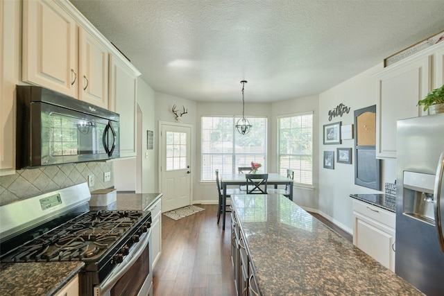 7503 Revelwood Dr, Magnolia, TX 77354 - kitchen with appliances with stainless steel finishes, dark wood finished floors, decorative backsplash, baseboards, and decorative light fixtures