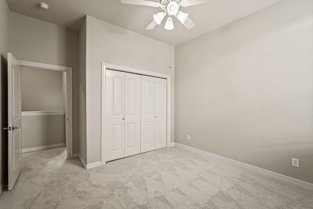 unfurnished bedroom featuring carpet, a closet, baseboards, and a ceiling fan