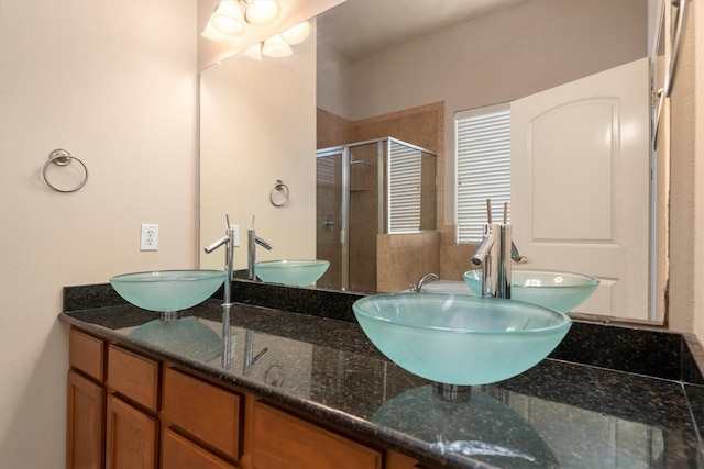full bathroom featuring a shower stall and double vanity