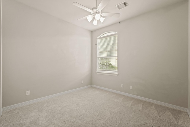spare room with light colored carpet, baseboards, and ceiling fan