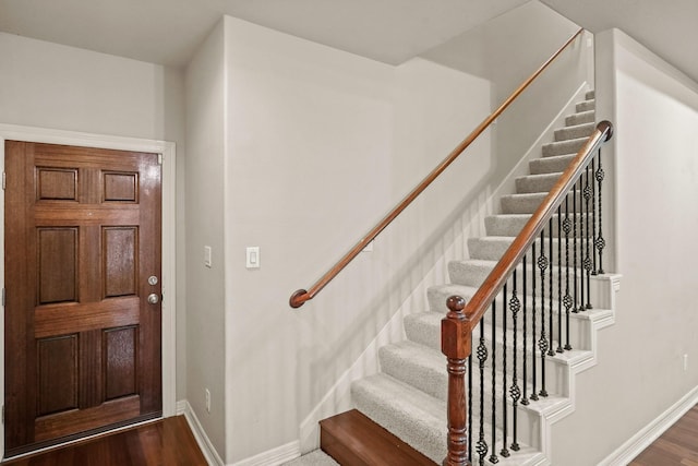 stairs with baseboards and wood finished floors