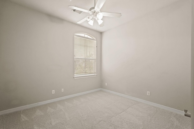 spare room with ceiling fan, light colored carpet, and baseboards