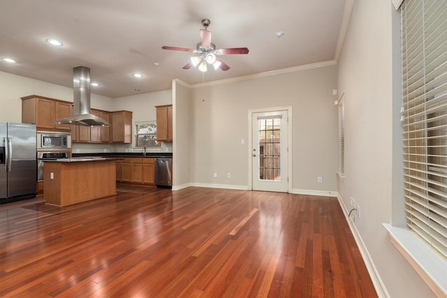 kitchen with stainless steel appliances, island range hood, dark countertops, ceiling fan, and dark wood finished floors