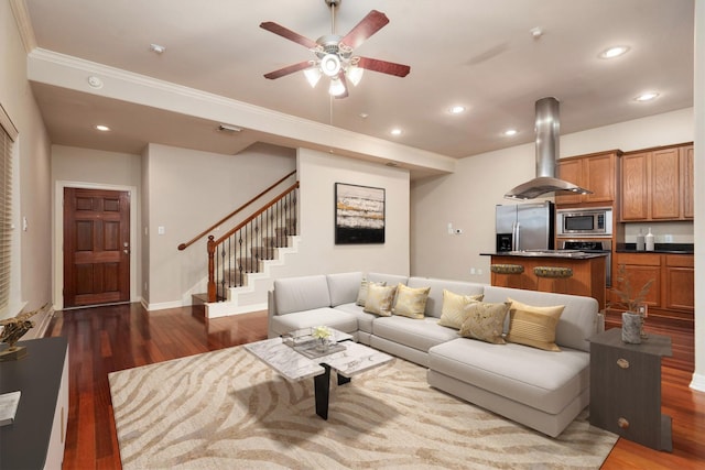 living room with stairs, wood finished floors, ceiling fan, ornamental molding, and recessed lighting