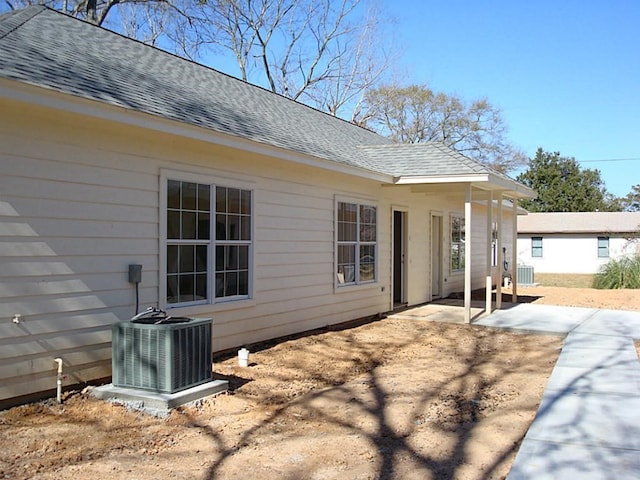 104 Longstreet Rd, Willis, TX 77378 - rear view of house featuring a shingled roof, cooling unit, and a patio