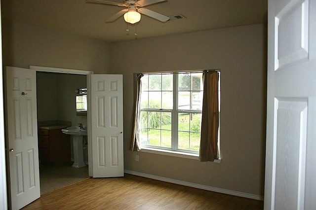 104 Longstreet Rd, Willis, TX 77378 - unfurnished bedroom featuring light wood finished floors, baseboards, a sink, and ensuite bathroom