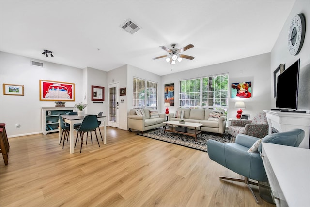 6607 Lake Woodlands Dr Unit 612, The Woodlands, TX 77382 - living area with a ceiling fan, light wood finished floors, baseboards, and a fireplace