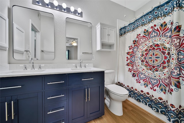 6607 Lake Woodlands Dr Unit 612, The Woodlands, TX 77382 - bathroom with toilet, wood finished floors, double vanity, curtained shower, and a ceiling fan