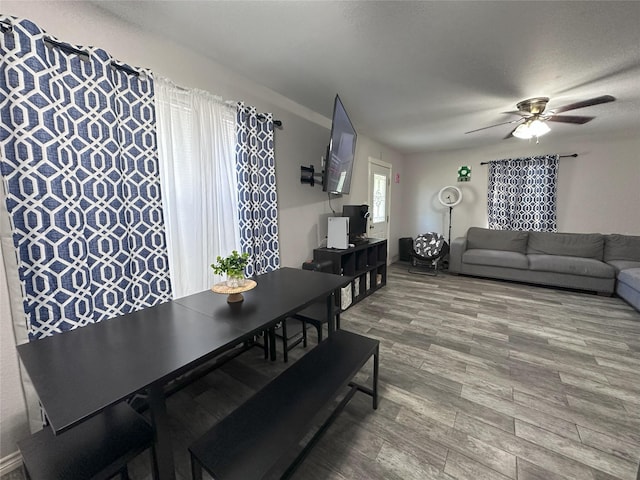 dining space with wood finished floors and ceiling fan