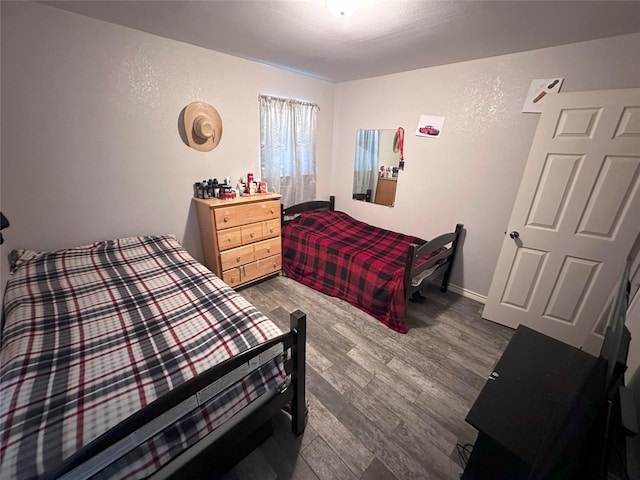 bedroom featuring wood finished floors and baseboards
