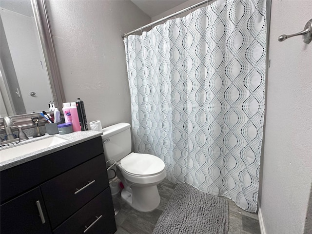 full bathroom with vanity, toilet, a textured wall, and a shower with shower curtain