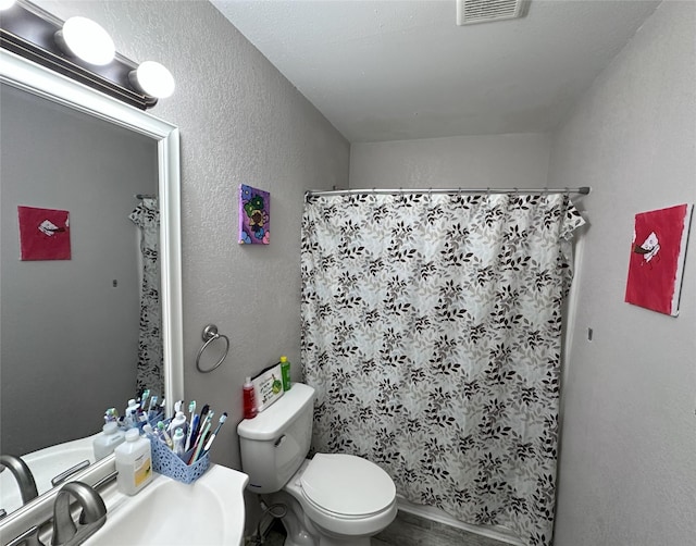full bathroom with toilet, a shower with shower curtain, a sink, and a textured wall