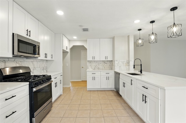 5318 Cilantro Ln, Baytown, TX 77521 - kitchen featuring appliances with stainless steel finishes, a sink, a peninsula, recessed lighting, and backsplash