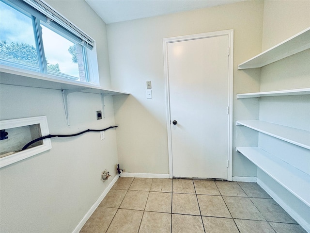 5318 Cilantro Ln, Baytown, TX 77521 - washroom featuring hookup for an electric dryer, light tile patterned floors, baseboards, and hookup for a washing machine