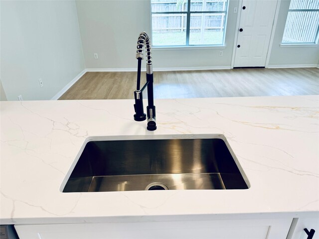 5318 Cilantro Ln, Baytown, TX 77521 - kitchen view of a sink, light wood finished floors, light stone countertops, and baseboards