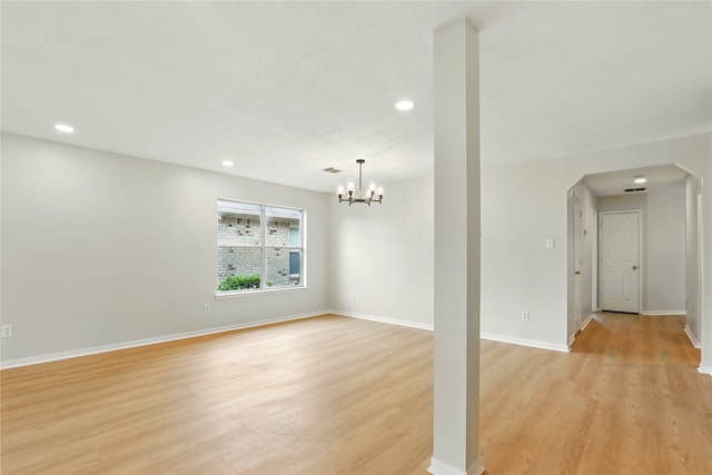 5318 Cilantro Ln, Baytown, TX 77521 - unfurnished living room with light wood finished floors, recessed lighting, baseboards, a chandelier, and arched walkways