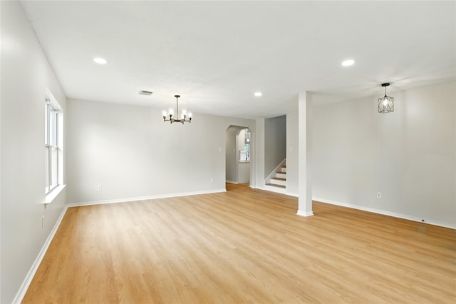 5318 Cilantro Ln, Baytown, TX 77521 - unfurnished living room featuring arched walkways, baseboards, light wood-style floors, recessed lighting, and stairway