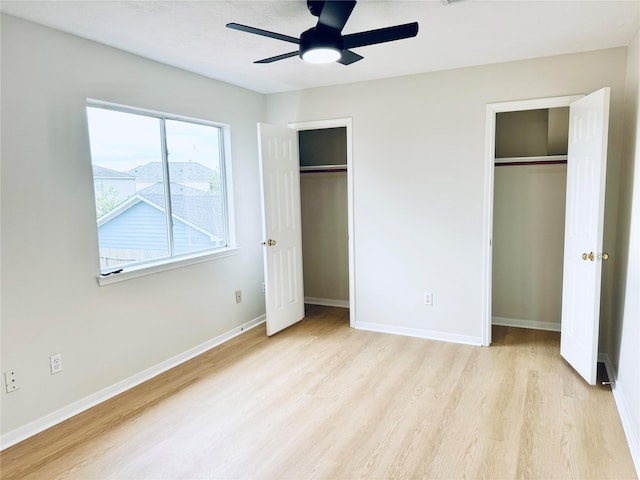 5318 Cilantro Ln, Baytown, TX 77521 - unfurnished bedroom featuring two closets, light wood-type flooring, baseboards, and ceiling fan