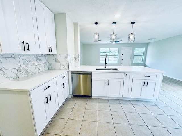 5318 Cilantro Ln, Baytown, TX 77521 - kitchen featuring dishwasher, a sink, a peninsula, tasteful backsplash, and white cabinetry