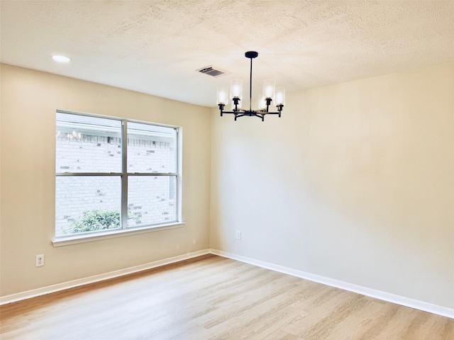 5318 Cilantro Ln, Baytown, TX 77521 - empty room with a chandelier, light wood-type flooring, baseboards, recessed lighting, and a textured ceiling