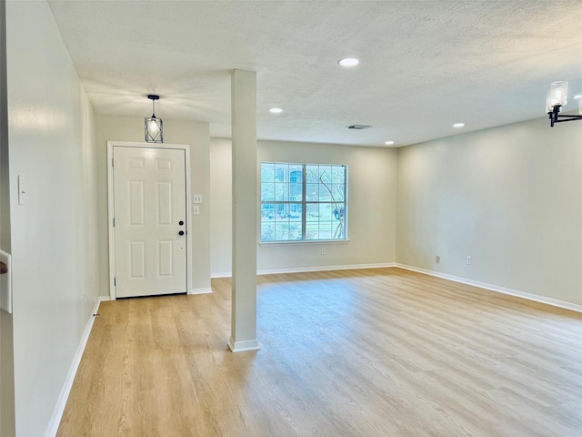 5318 Cilantro Ln, Baytown, TX 77521 - foyer featuring light wood-type flooring, baseboards, recessed lighting, and a textured ceiling