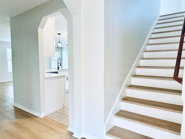 5318 Cilantro Ln, Baytown, TX 77521 - staircase with arched walkways, wood finished floors, and baseboards