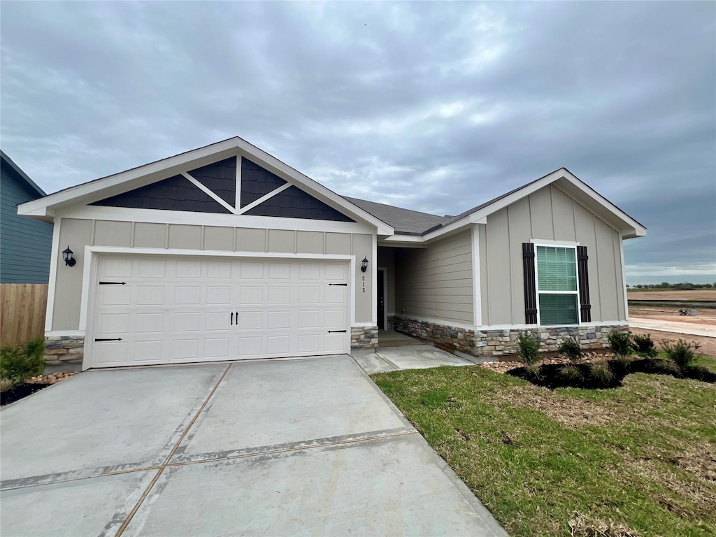 313 Kim Ln, Waller, TX 77484 - single story home with stone siding, board and batten siding, concrete driveway, and a garage