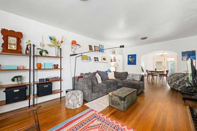 863 W 43rd St, Houston, TX 77018 - living room with arched walkways, wood finished floors, and a chandelier