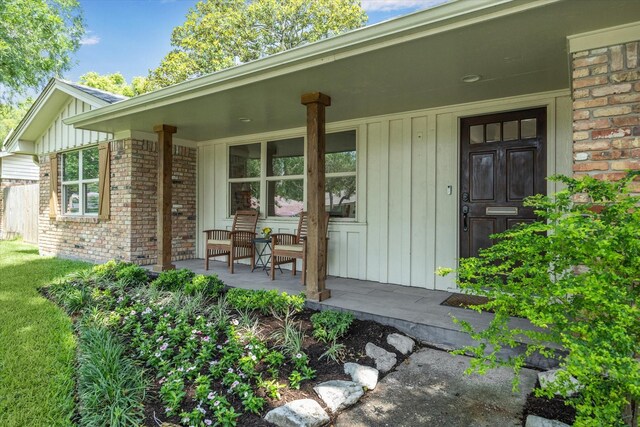 5402 Indigo St, Houston, TX 77096 - view of exterior entry featuring covered porch, board and batten siding, and brick siding