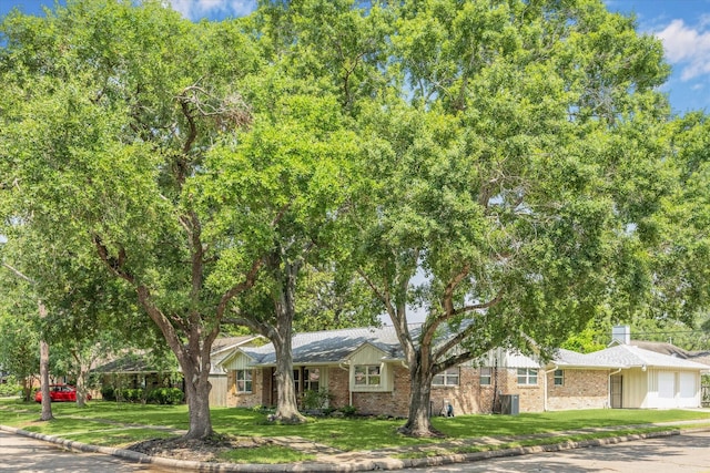 5402 Indigo St, Houston, TX 77096 - view of front facade featuring a front lawn, brick siding, and a chimney