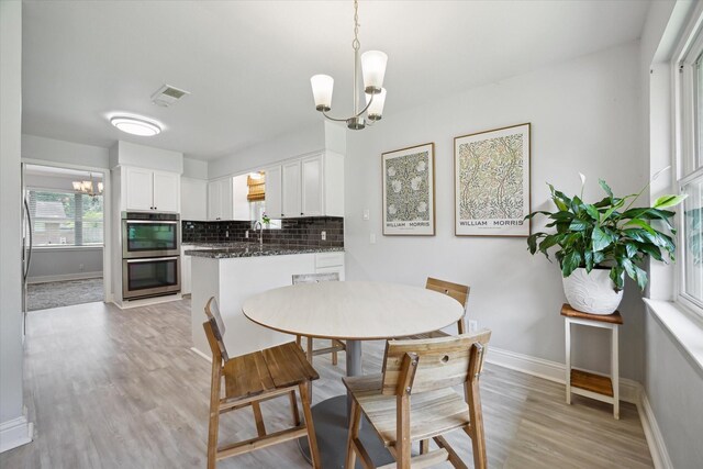 5402 Indigo St, Houston, TX 77096 - dining space featuring a chandelier, light wood finished floors, and baseboards