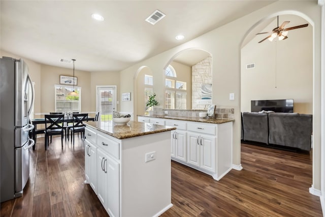 kitchen with stainless steel fridge with ice dispenser, dark wood finished floors, light stone counters, white cabinets, and recessed lighting