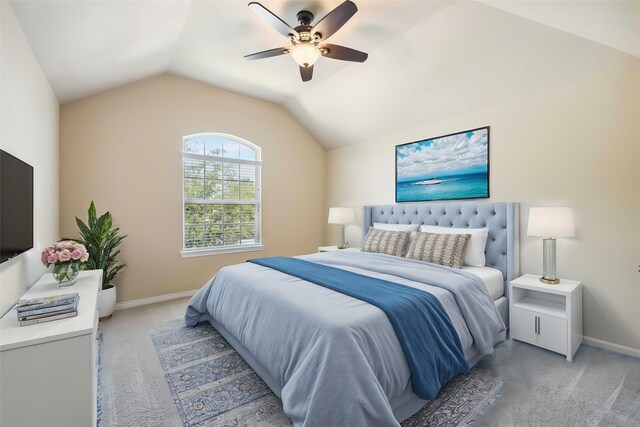 bedroom with light carpet, vaulted ceiling, baseboards, and a ceiling fan