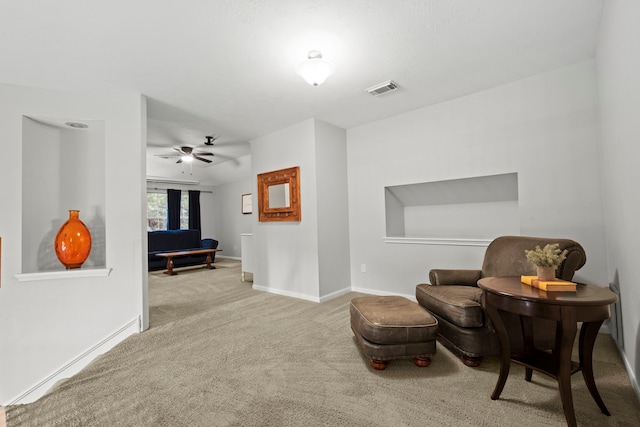 sitting room with carpet, ceiling fan, and baseboards