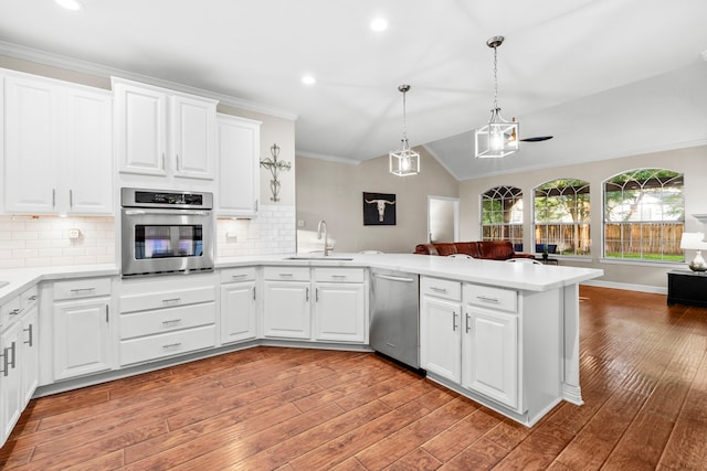 6503 Ambercrest Ct, Spring, TX 77389 - kitchen with stainless steel appliances, a sink, a peninsula, open floor plan, and light wood-type flooring