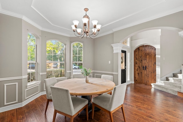 6503 Ambercrest Ct, Spring, TX 77389 - dining area with arched walkways, hardwood / wood-style flooring, a chandelier, a tray ceiling, and stairs