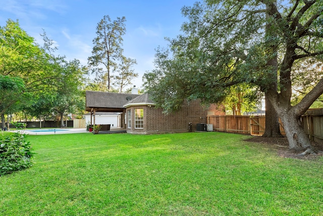 back of property with a chimney, brick siding, central AC unit, and a shingled roof