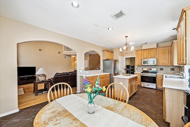 3119 Five Oaks Dr, Missouri City, TX 77459 - dining space featuring arched walkways, a chandelier, dark tile patterned floors, and baseboards