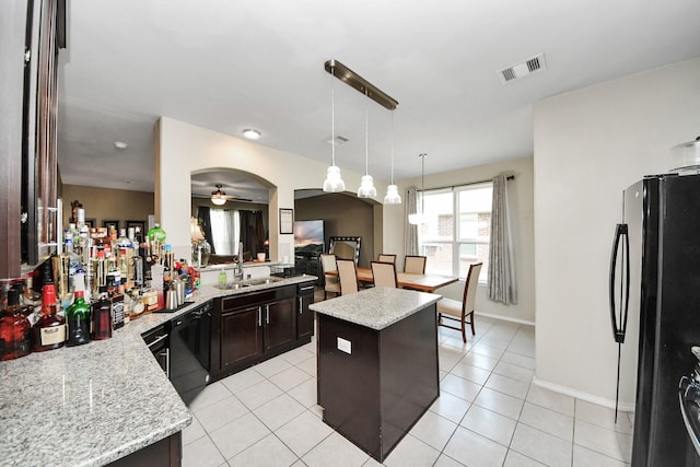 9703 Tipton Sands Dr, Humble, TX 77396 - kitchen with black appliances, a ceiling fan, a sink, dark brown cabinets, and a center island