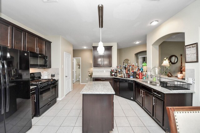 9703 Tipton Sands Dr, Humble, TX 77396 - kitchen featuring black appliances, a sink, a center island, arched walkways, and dark brown cabinetry