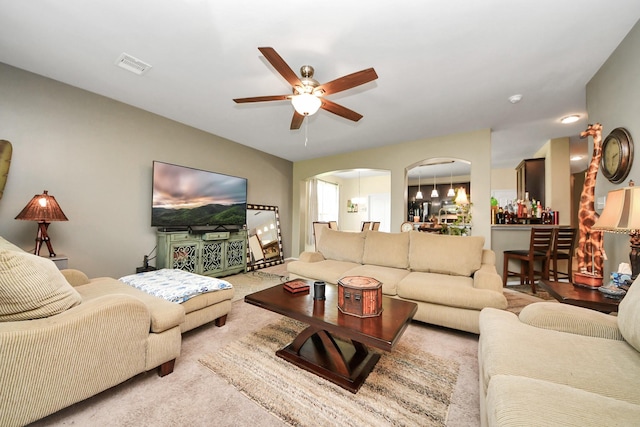 9703 Tipton Sands Dr, Humble, TX 77396 - living area with arched walkways, a ceiling fan, and carpet